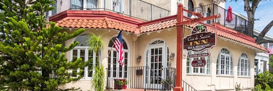 Exterior view of Casa De Suenos Bed & Breakfast in St Augustine featuring Spanish-style architecture and tropical landscaping.