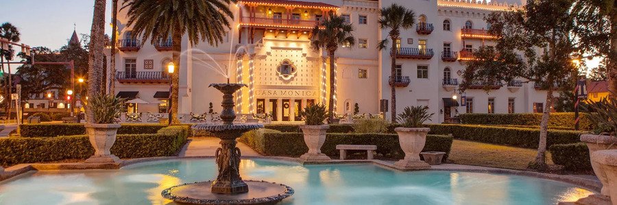 Casa Monica Resort & Spa in St Augustine featuring elegant architecture, illuminated gardens, and a decorative fountain at dusk.