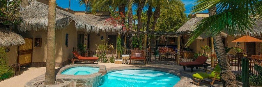 coco-cabanas-loreto-boutique-garden-pool-retreat | Beach Travel Destinations Coco Cabanas boutique stay in Loreto, Mexico featuring a peaceful garden courtyard with a small turquoise pool, palm trees, shaded seating areas, and private cabanas designed for a quiet and relaxing escape