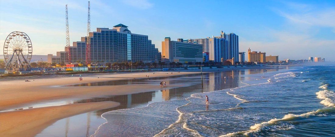 Daytona Beach Florida | Oceanfront Beaches & Attractions Daytona Beach oceanfront with sandy shores, Atlantic Ocean waves, beachfront hotels, and the Daytona Beach Boardwalk Ferris wheel.