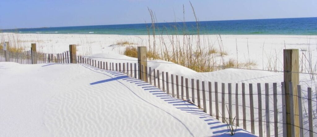 Emerald Coast Florida white sand dunes with sea oats and wooden fence along the Gulf Coast beach