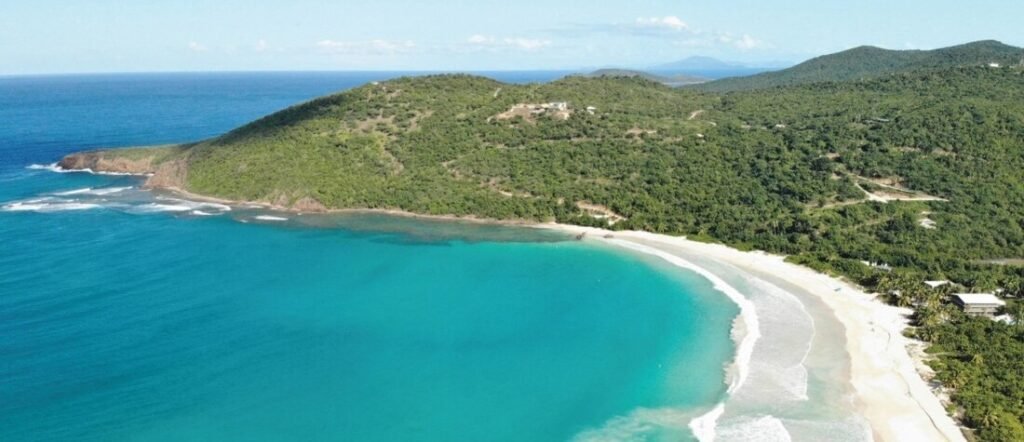 Aerial view of the crescent shape and turquoise waters of Flamenco Beach.