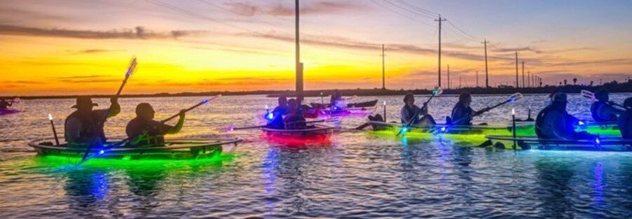 Illuminated clear kayaks glowing at sunset during a guided tour in Rockport Texas.