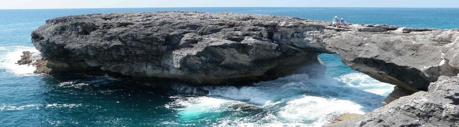 Natural rock arch at Hole-in-the-Wall on South Abaco with waves crashing below.