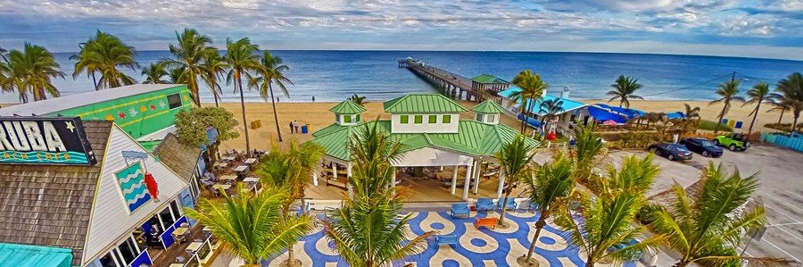 Lauderdale-by-the-Sea beach, fishing pier, palm trees, and oceanfront promenade in South Florida.