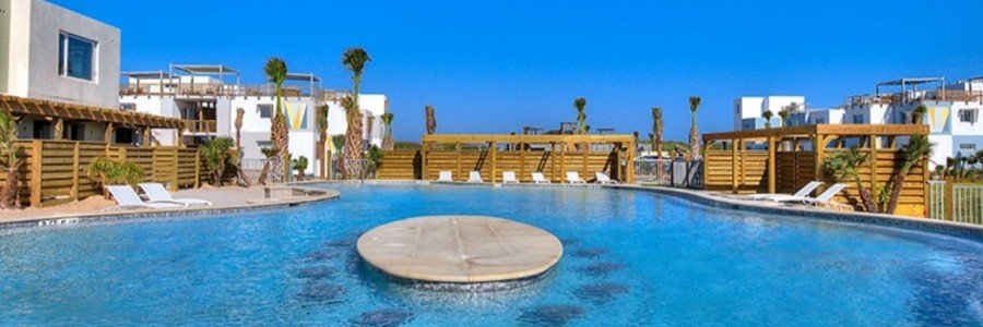 Large resort-style pool at Lively Beach Condominiums surrounded by modern coastal accommodations in Port Aransas.