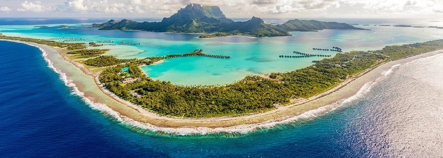 Aerial view of Marquesas Islands with lagoon, reef, and lush mountain landscape