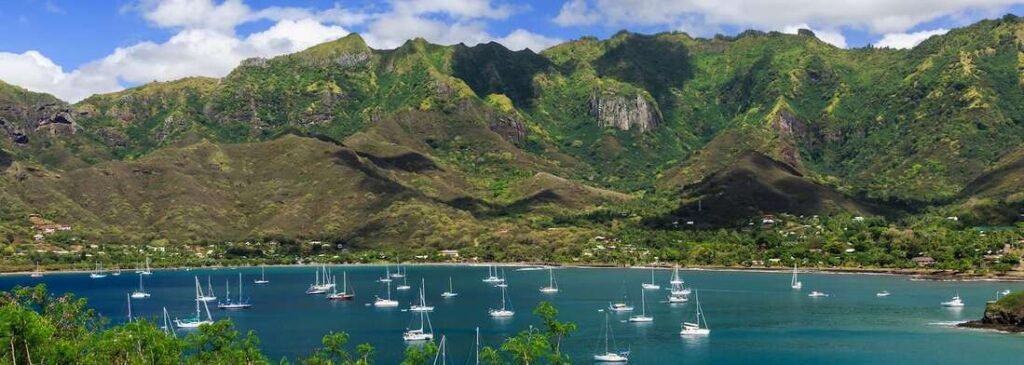 Marquesas Islands bay with sailboats and lush green mountains in French Polynes