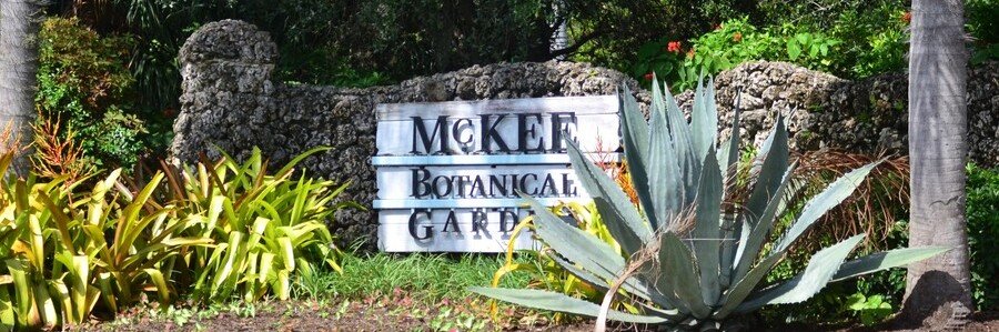 McKee Botanical Garden | Beach Travel Destinations Entrance sign surrounded by tropical plants at McKee Botanical Garden in Vero Beach, Florida.