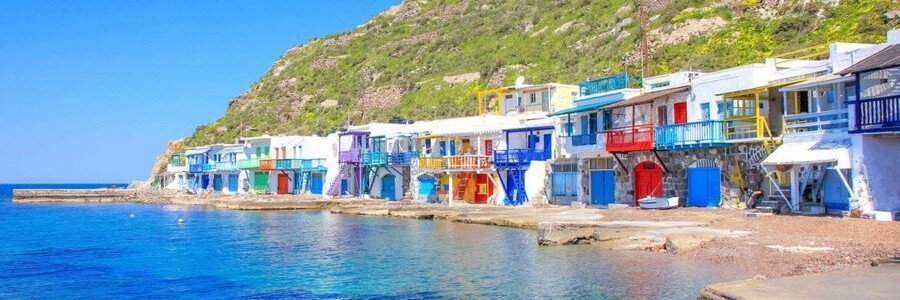 Colorful syrmata fishing houses along the waterfront in Milos, Greece.