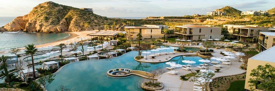 Main resort pool and beachfront buildings at Montage Los Cabos beside the rocky headlands of Santa Maria Bay.