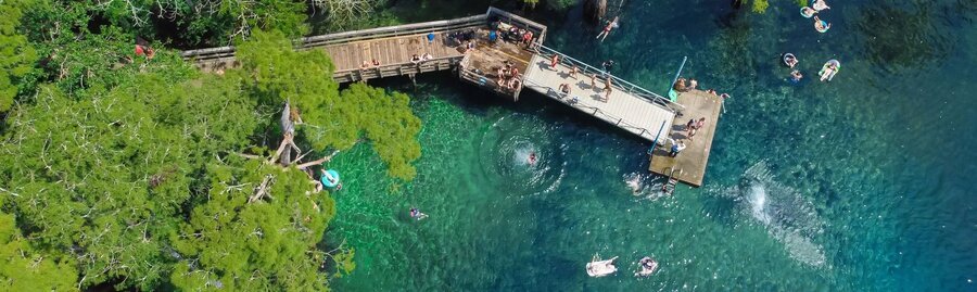 Aerial view of Morrison Springs in Florida with crystal clear turquoise water and wooden swimming platform