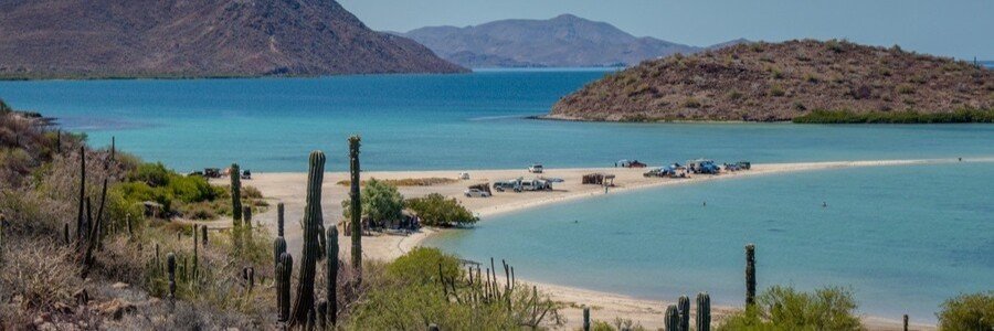 El Requesón sandbar in Bahía Concepción, Mexico, with turquoise water, desert hills, and a narrow strip of white sand connecting the beach to a small island