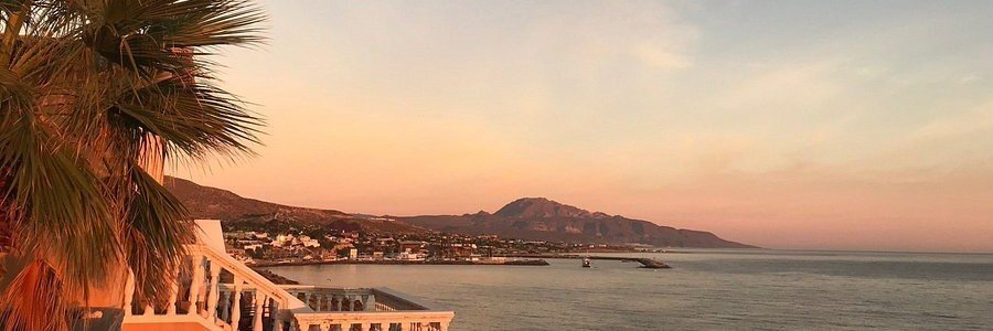 Sunset view over the coastline near Mulegé, Mexico, with warm golden light reflecting on the water and mountains in the distance