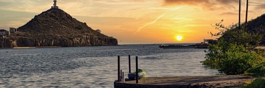 Sunset over Mulegé, Mexico, with a hilltop mission overlooking the water and warm colors reflecting across the bay