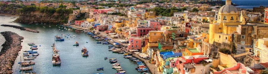 Colorful waterfront buildings and fishing boats lining the harbor in Naples Italy