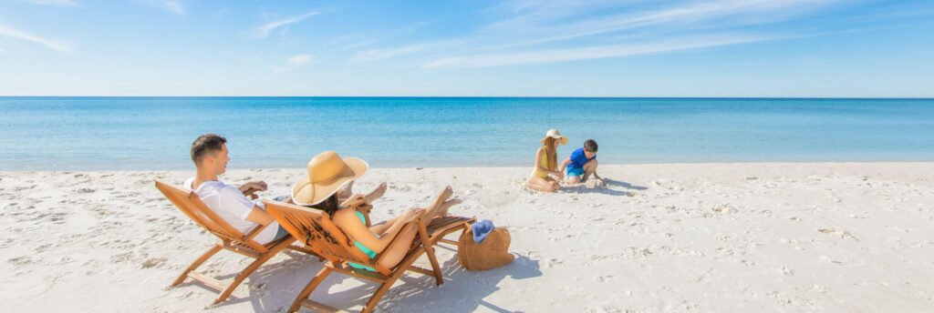 Family relaxing on Navarre Beach Florida with white sand, beach chairs, and calm Gulf Coast water