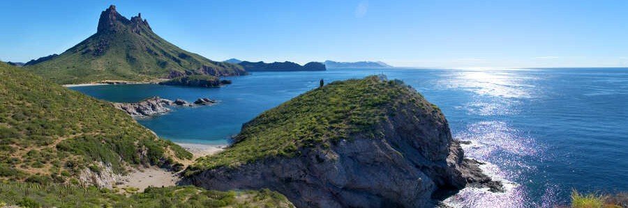 Beautiful coastal landscape near San Carlos Sonora with rocky cliffs, calm blue Sea of Cortez water, desert hills, and scenic ocean views under a sunny sky.