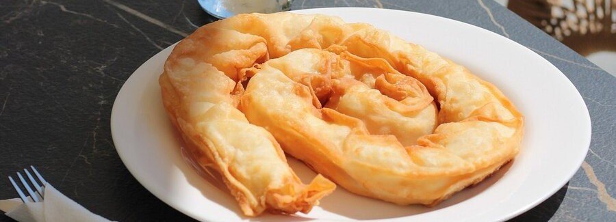 Skopelos cheese pie strifti traditional Greek spiral pastry with crispy layers on a plate