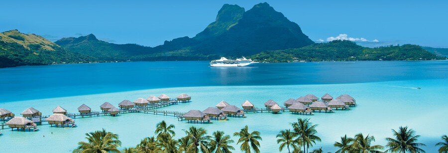 Society Islands lagoon with overwater bungalows, cruise ship, and mountain backdrop