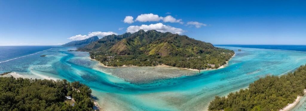 Aerial view of Moorea in the Society Islands with lush mountains, curved lagoon, and vibrant coral reef