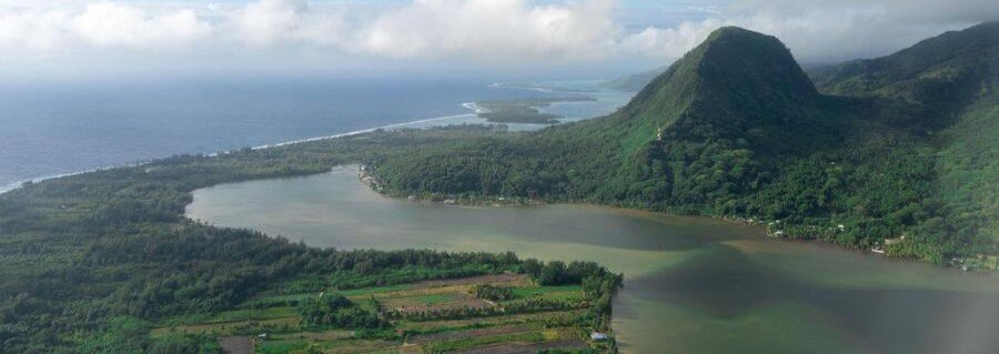 Lush mountain and coastline in the Society Islands with lagoon and tropical forest in French Polynesia