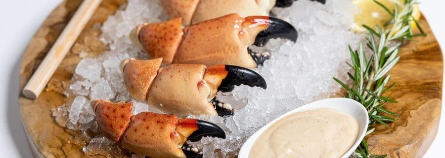 Close-up of Florida stone crab claws on ice with mustard sauce and lemon at Boca Raton seafood restaurant