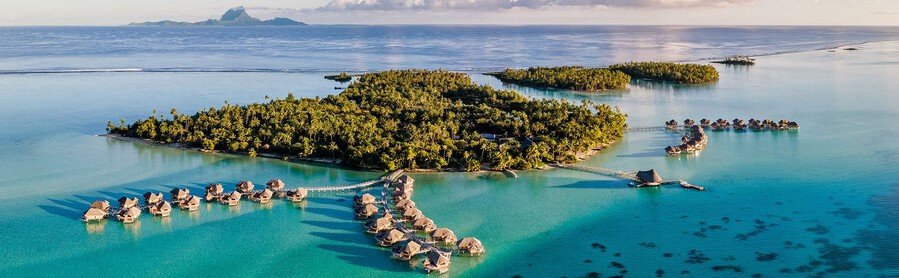 Aerial view of Taha’a island with overwater bungalows and turquoise lagoon in French Polynesia