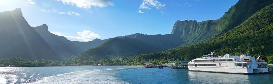 Ferry near Tahiti coastline with mountains and lagoon water