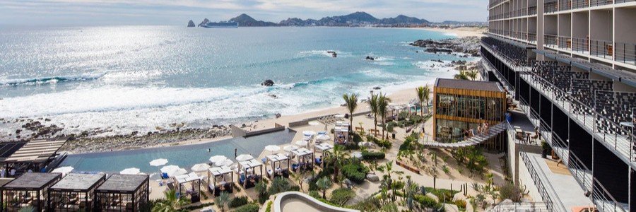 Oceanfront pool and terraces at The Cape, a Thompson Hotel, with Land’s End visible across the water.