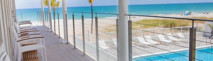 Oceanfront balcony overlooking the beach and pool at Tides Inn Hotel in Fort Lauderdale.
