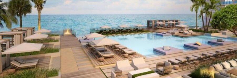 Modern oceanfront swimming pool at W South Beach with luxury private cabanas, floating daybeds, fire pits, and clear Atlantic Ocean views.
