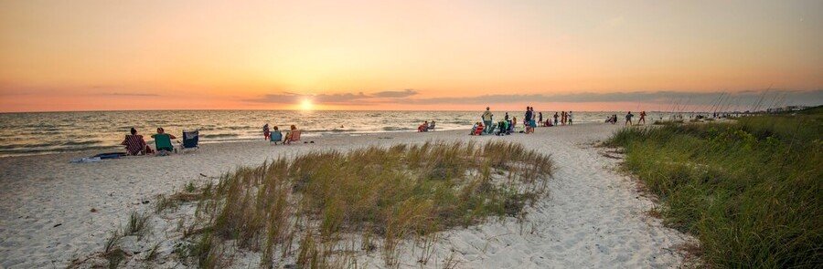 Bonita Springs beach at sunset with sandy dunes, Gulf waves, and evening sky