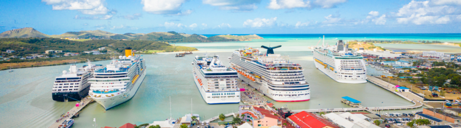 Cruise ships docked at the port of St. John’s, Antigua with turquoise water and island scenery.
