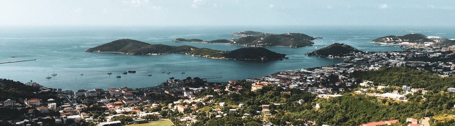 Aerial view of St. Thomas and surrounding islands in the U.S. Virgin Islands with turquoise water, green hills, and coastal towns.