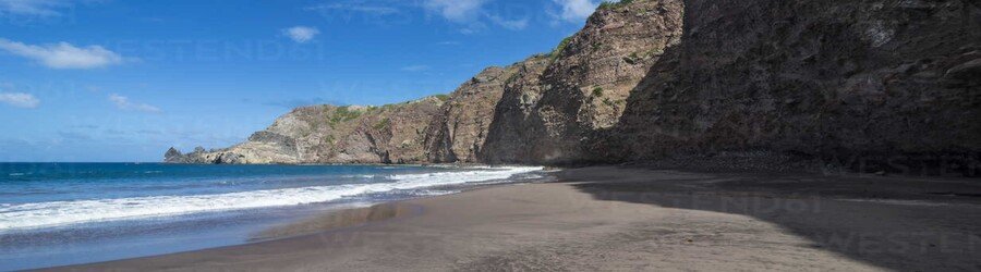 Well’s Bay on Saba with dark sand, cliffs, and calm turquoise water along the shoreline