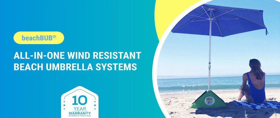 beachBUB all-in-one wind-resistant beach umbrella anchored in the sand beside a woman sitting near the ocean.