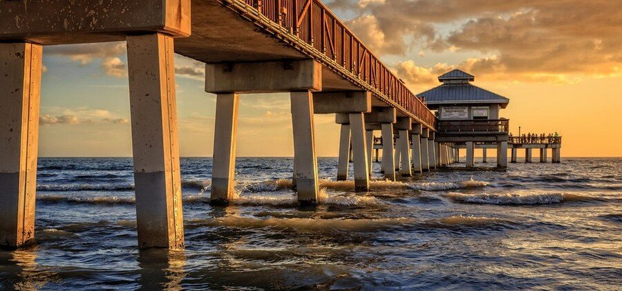 Fort Myers Beach pier extending over Gulf waters at sunset