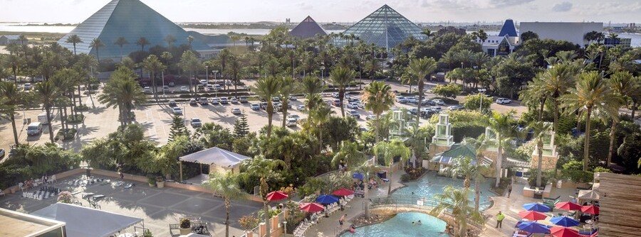 Palm Beach at Moody Gardens in Galveston Texas with lagoon pool, tropical landscaping, and pyramid buildings in background