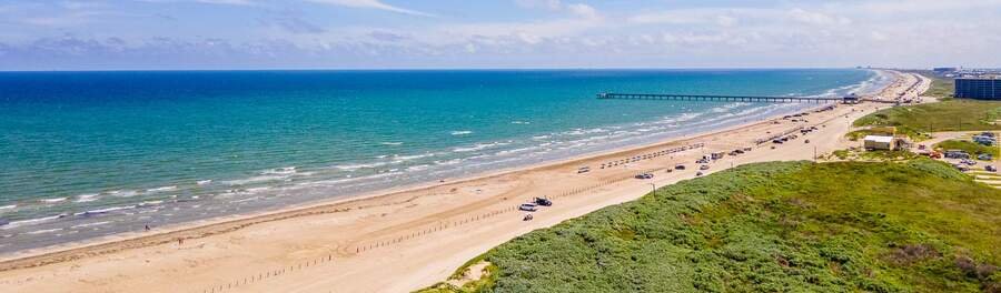 Port Aransas Texas beach with wide sandy shoreline, Gulf waves, beach pier, and coastal scenery