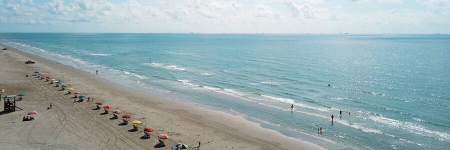 Stewart Beach Galveston Texas with sandy shoreline, Gulf water, beach umbrellas, and family-friendly beach scene
