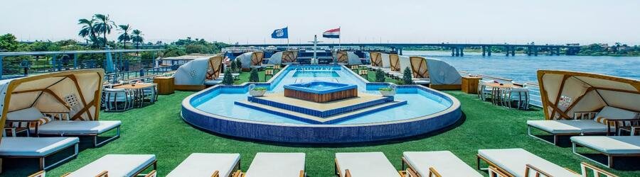 Cruise ship sundeck with pool, lounge chairs, and ocean views