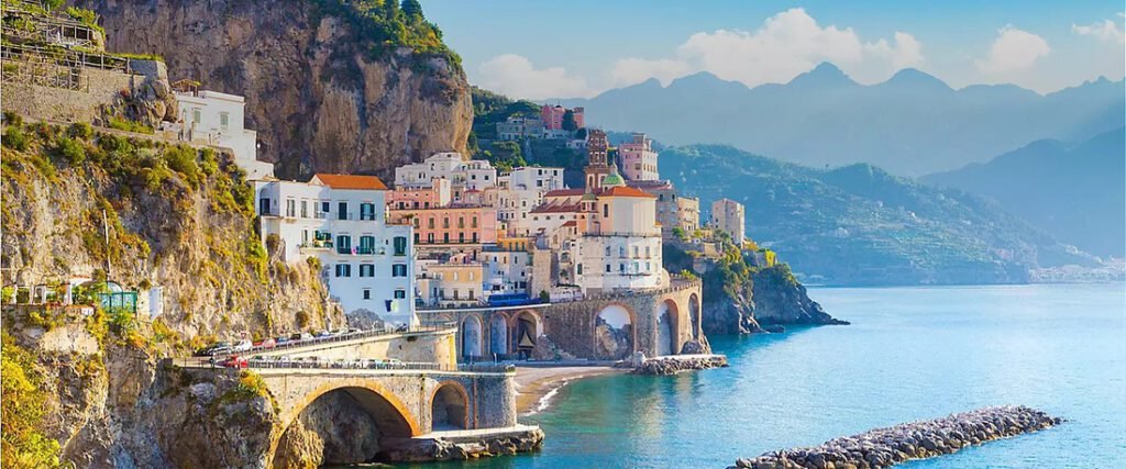 Amalfi Coast Italy with colorful cliffside buildings, coastal road, and clear blue Mediterranean water.  Enjoy a Western Caribbean Cruise.
