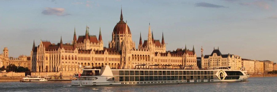 Danube River cruise ship sailing in front of the Hungarian Parliament Building in Budapest.