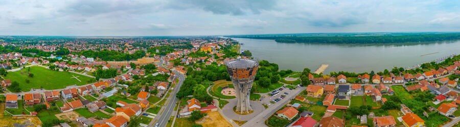 Aerial view of Vukovar, Croatia, beside the Danube River with the city's landmark water tower visible.