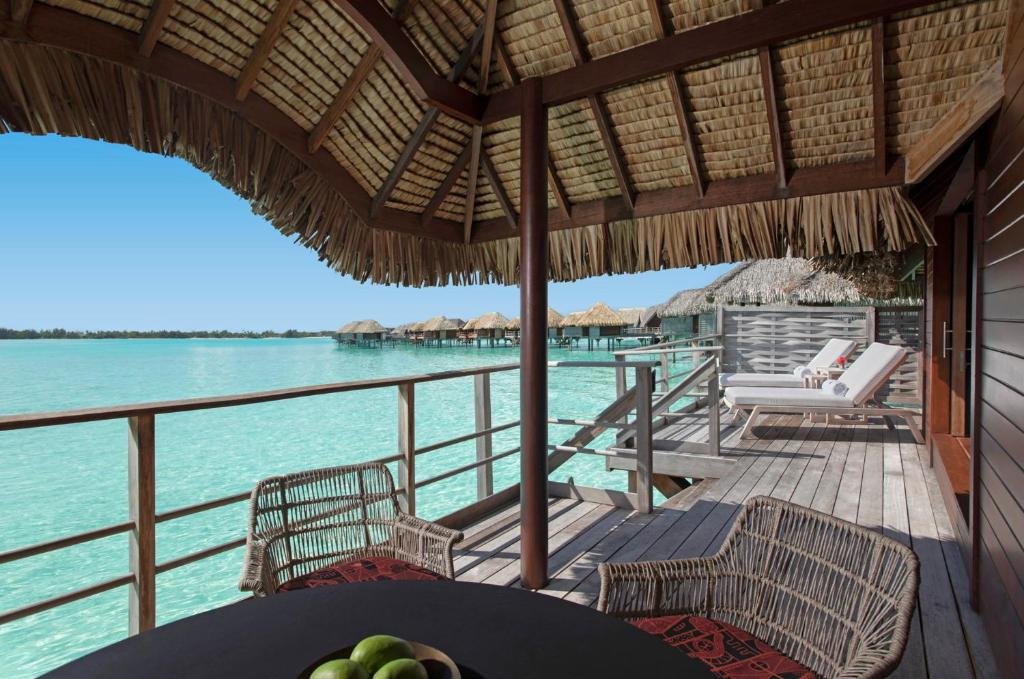 Overwater bungalows at Four Seasons Resort Bora Bora with lagoon views, interior living space, and private deck over turquoise water