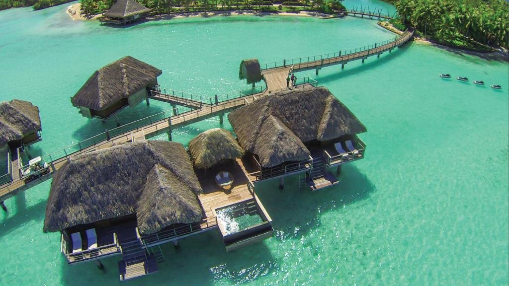 Overwater bungalows at Four Seasons Resort Bora Bora with lagoon views, interior living space, and private deck over turquoise water
