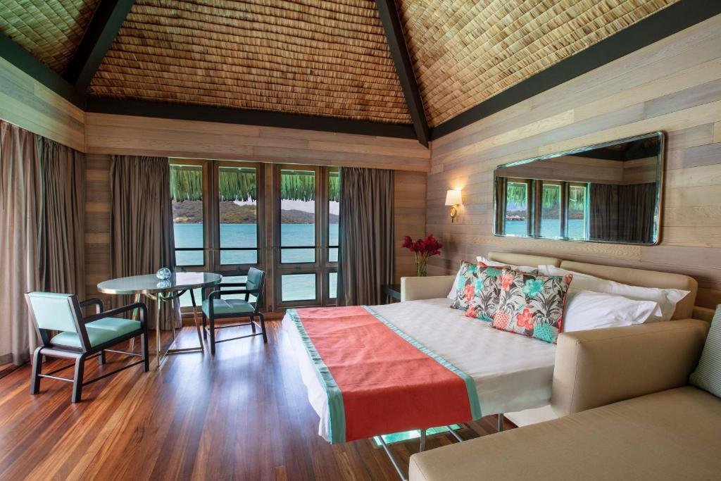 Luxury bedroom and living space at The St Regis Bora Bora Resort with overwater bungalows and turquoise lagoon views