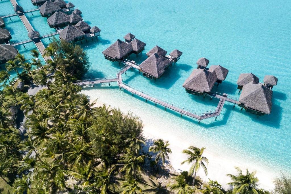 Luxury bedroom and living space at The St Regis Bora Bora Resort with overwater bungalows and turquoise lagoon views