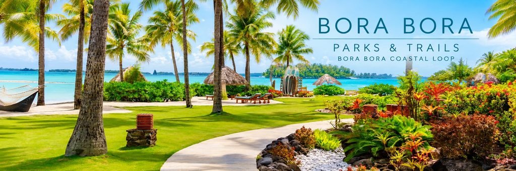 Palm-lined coastal pathway in Bora Bora winding through lush tropical gardens toward a beautiful turquoise lagoon.